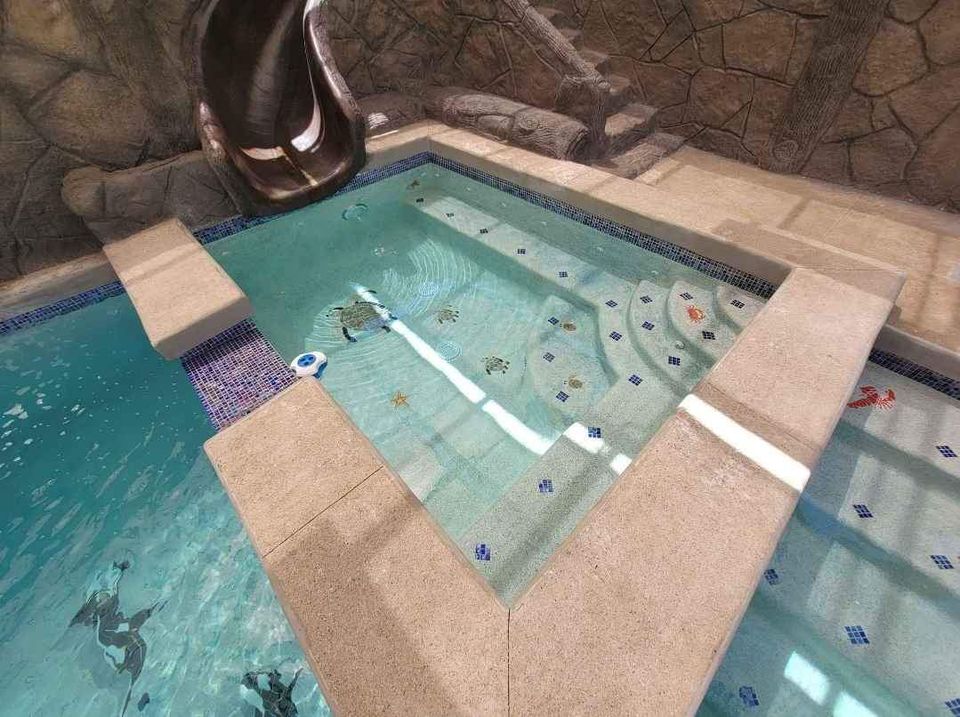 Jacuzzi con resbaladilla y mosaicos decorativos